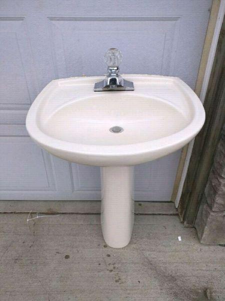 Off white pedestal sink with faucet