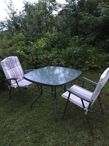 Glass patio table and 2 folding chairs (beige/brown )