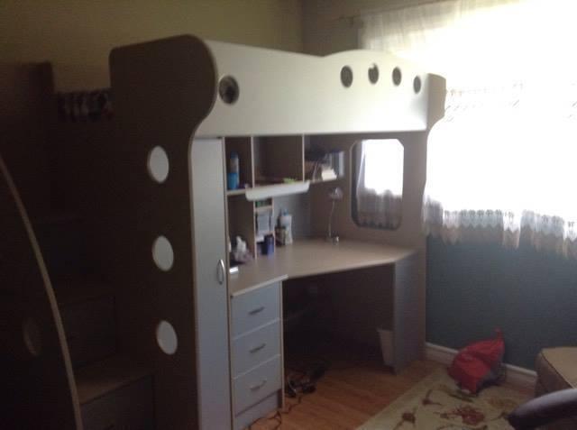 Bunk bed with storage stairs, closet, and work desk